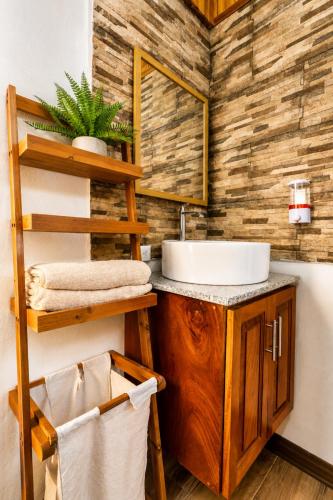 a bathroom with a sink and a wooden wall at Cabañas Bella Vista in Hojancha