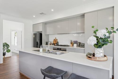 a white kitchen with a vase of flowers on a counter at The Tobias in Perth