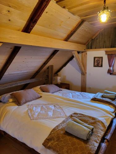 a large bed in a room with wooden ceilings at Oddih v Srčni hiški in Dvor