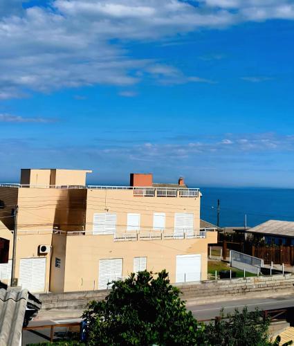 a building with the ocean in the background at Loft 102 Farol de Santa Marta in Laguna