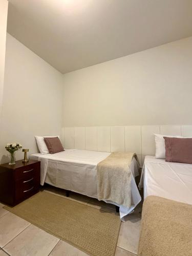a bedroom with two beds and a dresser and sidx sidx sidx sidx at Recanto Canuto in Diamantina