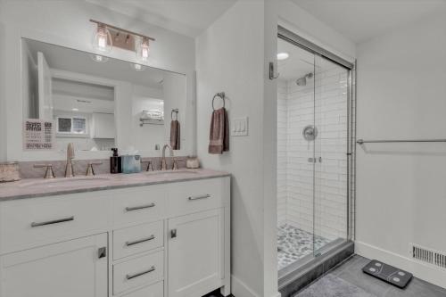 a white bathroom with two sinks and a shower at Charming Washington Park Getaway in Denver
