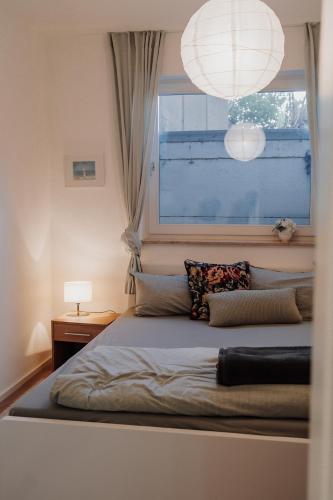 a bedroom with a bed with a window and a lamp at Gemütliche Ferienwohnung in Riedlingen