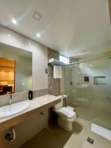 ein Badezimmer mit Toilette, Waschbecken und Dusche in der Unterkunft Novares Hotel in Goiânia
