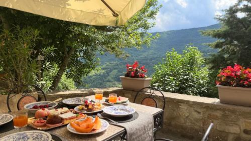 ein Tisch mit Tellern voller Essen und Aussicht in der Unterkunft Poet's Rest in Pieve Santo Stefano