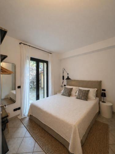 a white bedroom with a bed and a window at Riviera Panorama Retreat in Alassio