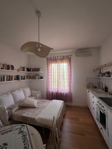 a bedroom with a bed and a couch and a window at Bloom as you are in Bologna