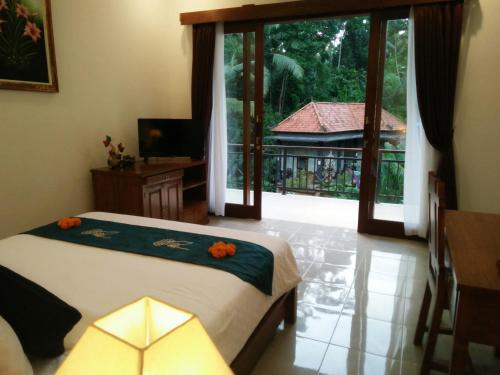 Ubud Harmony Private Villa and Pool في أوبود: غرفة نوم بسرير وباب زجاجي منزلق