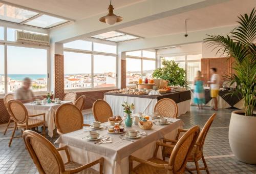 a restaurant with tables and chairs and people in the background at Eden Torre Canne in Torre Canne