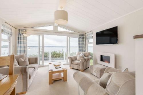 a living room with a couch and a tv at Bay View 2-Bed Lodge with Glorious Harbour View and Balcony in Poole