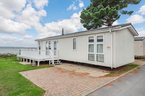 a white house with a large porch at Bay View 2-Bed Lodge with Glorious Harbour View and Balcony in Poole