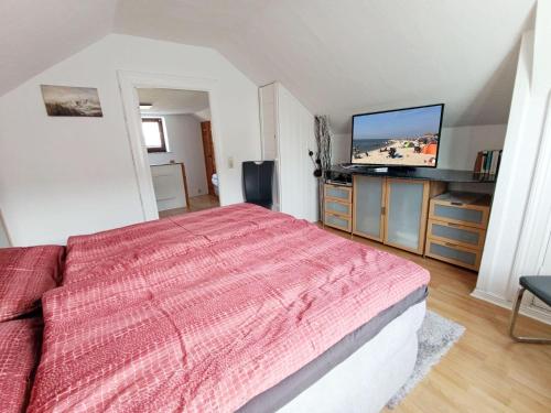 a bedroom with a bed and a flat screen tv at Ferienhaus-Kassiopeia in Laboe