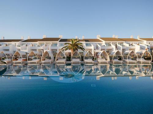 a view of a resort with a pool of water at Lago Resort Menorca - Casas del Lago Adults Only in Cala en Bosc