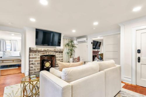 a living room with a white couch and a fireplace at Garden Level 2 bed 2 bath Apartment in Historic District in Savannah