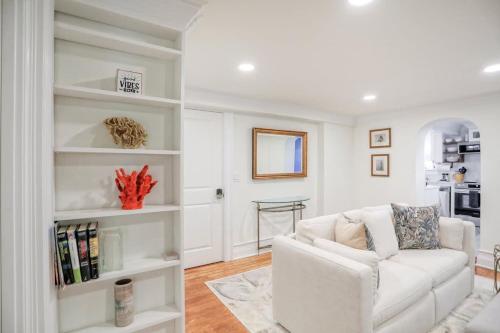 a living room with a white couch and a kitchen at Garden Level 2 bed 2 bath Apartment in Historic District in Savannah