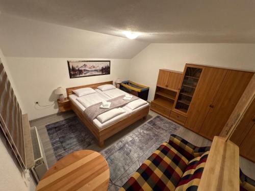 a small bedroom with a bed and a couch at Apartman Lili in Bihać