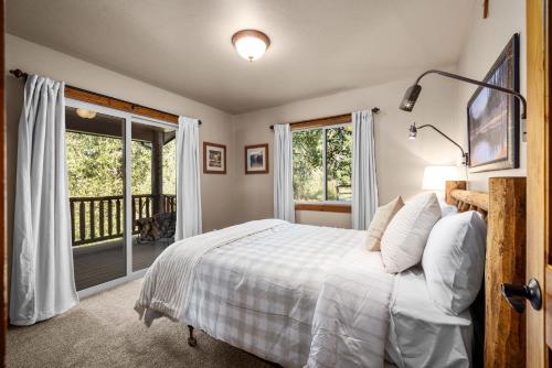 a bedroom with a bed and a balcony at Glacier River Ranch - South Fork in Columbia Falls