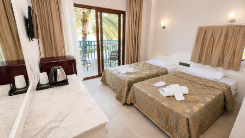 a hotel room with two beds and a balcony at del Mare Hotel Ölüdeniz in Oludeniz