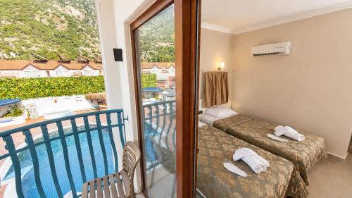 a room with a balcony with a view of a pool at del Mare Hotel Ölüdeniz in Oludeniz
