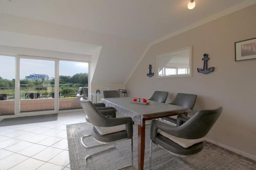 a dining room with a table and chairs at FW2 Deichperle in Wremen