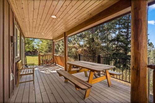 a wooden deck with a picnic table and a bench at Glacier River Ranch - North Fork in Columbia Falls