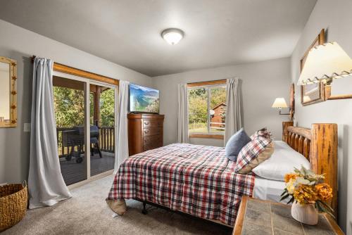 a bedroom with a bed and a sliding glass door at Glacier River Ranch - North Fork in Columbia Falls