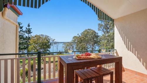 a table on a balcony with a plate of food on it at Tinaroo Lodge Lakeview Escape with Pool Access in Tinaroo