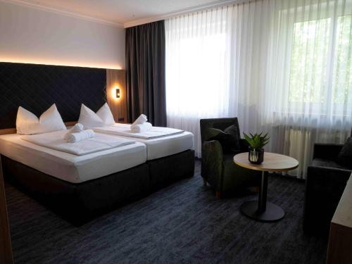 a hotel room with a large bed and a chair at Hotel Zum Steinhof in Bad Blankenburg