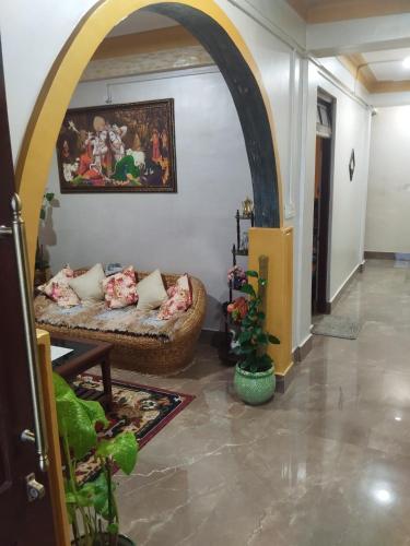 a living room with a couch and an archway at Laligurash in Mirik