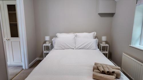 a bedroom with a bed with white sheets and pillows at Hallbottom Farm Cottage in Stokenchurch