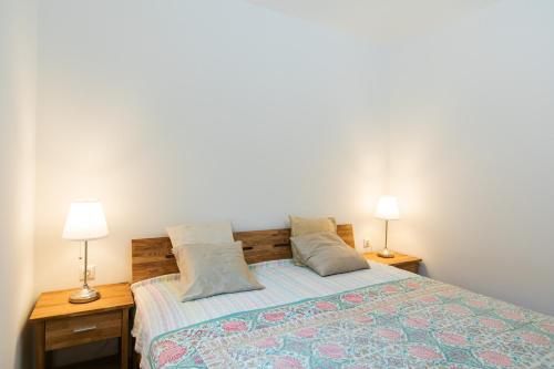 a bedroom with a bed with two lamps on two tables at Appartment am Mondsee in Mondsee