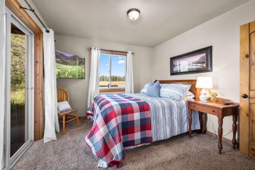 a bedroom with a bed and a desk and a window at Glacier River Ranch - Flathead in Columbia Falls