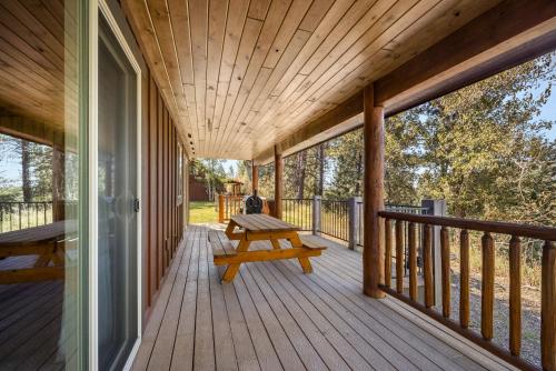 a wooden porch with a picnic bench on it at Glacier River Ranch - Middle Fork in Columbia Falls