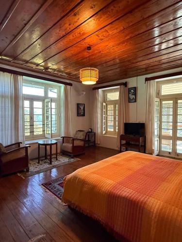 a bedroom with a large bed and wooden ceilings at Deodar Manor - Guest House Khajjiar in Khajjiar 