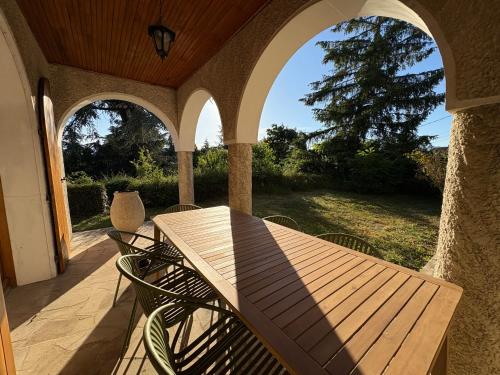 a wooden table and chairs on a patio at Los Arcos in Annonay