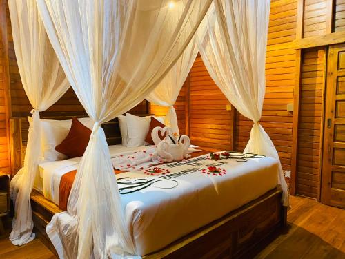 a bedroom with a bed with white drapes at Pandawa Villa Sidemen in Karangasem