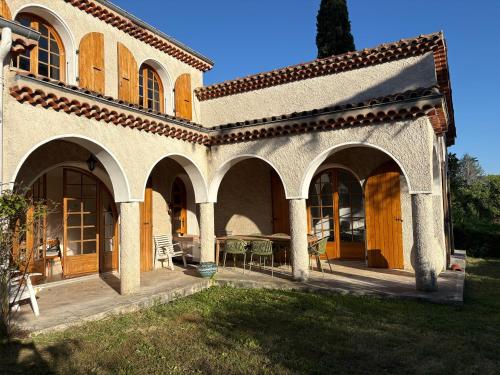 a building with a patio with a table and chairs at Los Arcos in Annonay