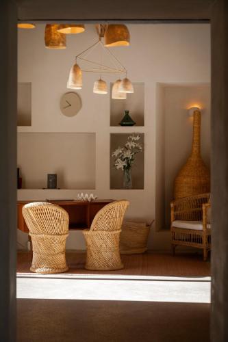 a room with wicker chairs and a table and a vase at Boutique Hotel Jardines de Palerm in San Jose