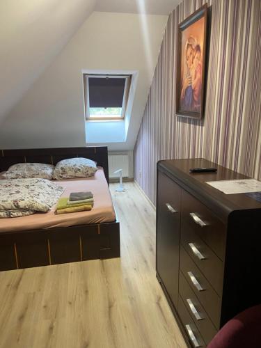 a bedroom with a bed with a dresser and a window at Willa Faustynka in Nałęczów