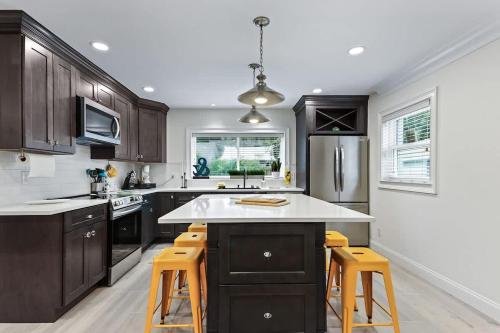 a kitchen with black cabinets and yellow bar stools at Battery Place in Savannah