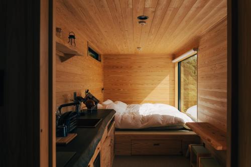a room with a bed and a sink in a wooden room at 森の宿 l ACAO FOREST 01 in Atami