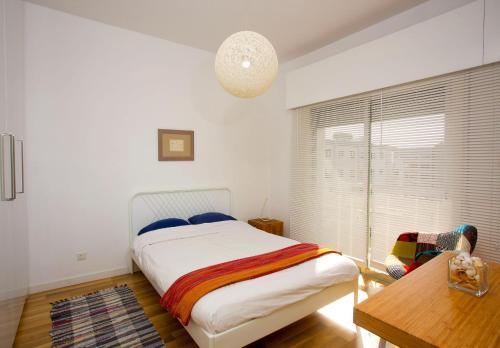a bedroom with a bed and a table and a window at SeaBreeze City Center Flat by TrulyCyprus in Limassol