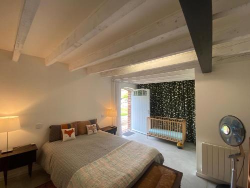 a bedroom with a bed and a baby crib at le relais Perrusson, Bed and breakfast et camping à la tuilerie in Écuisses