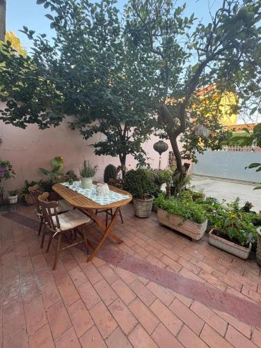 a patio with a table and chairs and trees at Casa di Nonna Vanda in Sestu