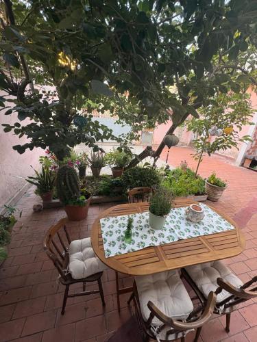 a wooden table and chairs on a patio with plants at Casa di Nonna Vanda in Sestu