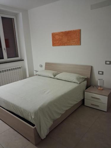 a bedroom with a large bed with a wooden headboard at Il Borgo in Lurago D'Erba 