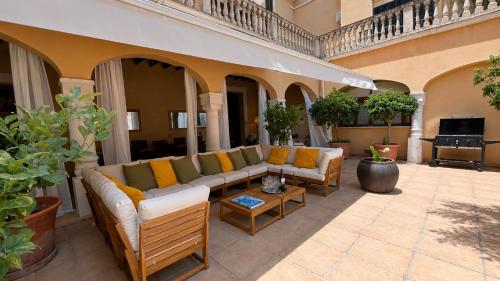 a patio with couches and a table and plants at Villa Nekazabal in Sa Pobla