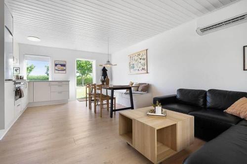 a living room with a black couch and a table at SB134-Sydals-Osterbyvej-54-B in Østerby