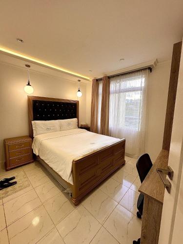 ein Schlafzimmer mit einem großen Bett und einem Fenster in der Unterkunft Residence Next Door Green Zone in Kiambu