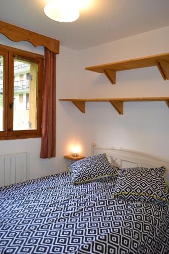 a bedroom with a bed and a window at Appartement Orelle spa et piscine in Orelle